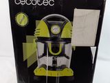 an open box of a green and black coffee maker sitting on top of a white surface