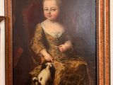 un tableau représentant une petite fille avec un chat accroché au mur