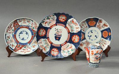 trois assiettes et une tasse sont posées sur un support, sur une surface grise