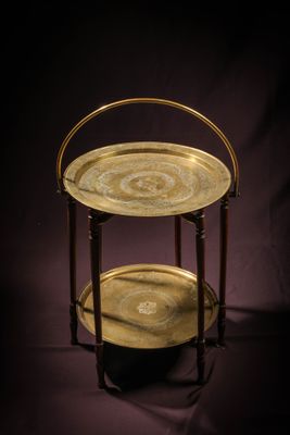 two tiered brass serving trays on a dark background