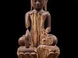une image représentant la statue d'une personne assise sur une souche d'arbre