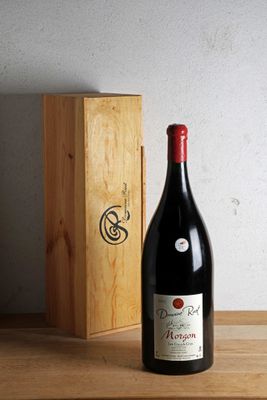 une bouteille de vin posée sur une table à côté d'une caisse en bois