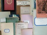 many old books on a table with papers on it