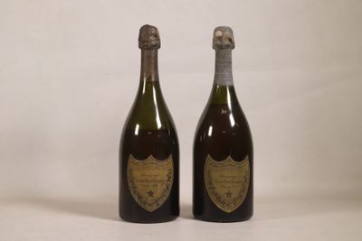 two bottles of champagne sitting next to each other on a white surface