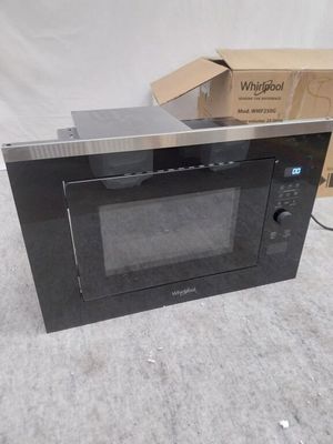 un micro-ondes posé par terre à côté d'un carton