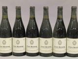 six bouteilles de vin sont alignées sur une table