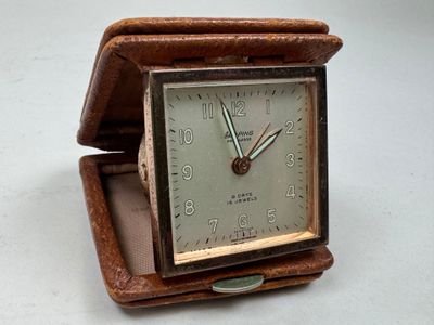 une petite horloge posée dans une boîte sur une table