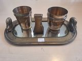 un plateau en argent posé sur une table, sur lequel se trouvent des tasses et des cuillères