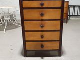 a small chest of drawers in the middle of a room