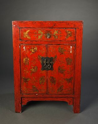 une armoire rouge ornée de motifs à la feuille d'or sur les portes