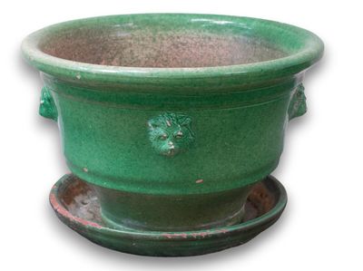 une jardinière verte posée sur une soucoupe
