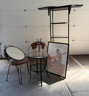 une table et des chaises dans un garage, avec un tableau accroché au mur