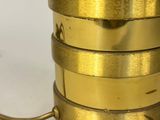 a close up of a gold colored lamp on a white surface