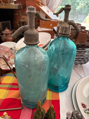 deux bouteilles en verre bleues posées sur une table recouverte d'une nappe rouge et jaune