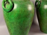 two green vases sitting next to each other on a table