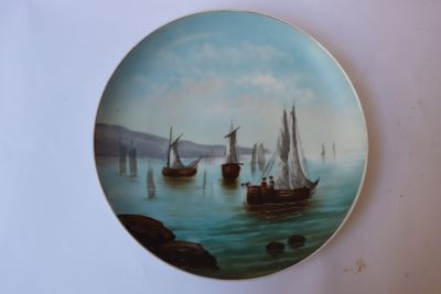 une assiette ornée d'une peinture représentant des bateaux sur l'eau