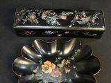 une petite boîte noire ornée d'un motif floral