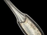 an old spoon with a metal handle on a black background