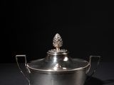 a silver plated casserole with a pine on top