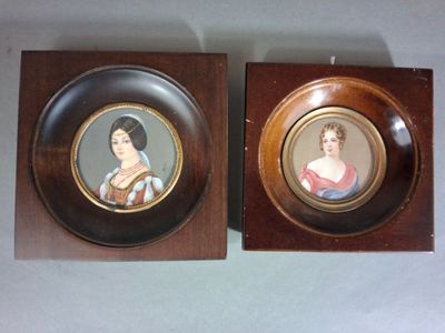 pair of framed portraits of a woman and a man on a wall