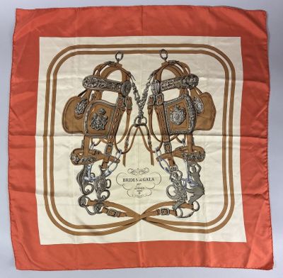 an orange and white scarf with a pair of horse boots on it