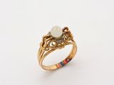 an image of a gold ring with a white opal stone