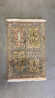 un tapis accroché au mur à côté d'un vase