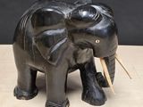 a black elephant statue on a table with a black background