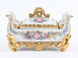 un plat de service blanc et doré orné de fleurs