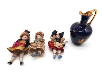 trois figurines posées à côté d'un vase sur une surface blanche