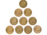 six pièces de monnaie britanniques différentes disposées en pyramide sur une surface blanche