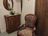 une chaise qui se trouve dans une pièce où il y a un miroir accroché au mur