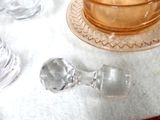 a glass candle holder on the table next to a glass candle