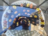 reflection of a person in a glass table with a plate of donuts on it