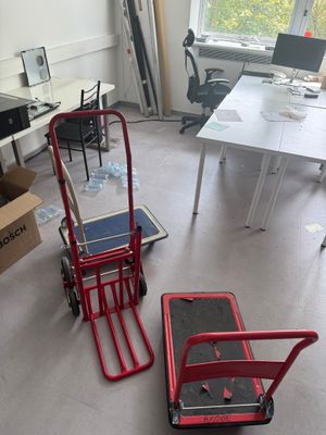 two red hand trucks sitting in the middle of a room