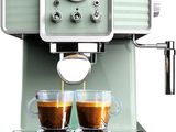 two cups of coffee being poured into a coffee machine