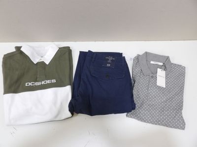 trois polos et pantalons pour homme posés sur une table