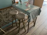 two stools sitting at a table with a blue checkered tablecloth