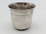 an antique silver cup on a white surface with a white background