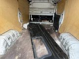 the inside of a van with the door open and the floor covered in plastic