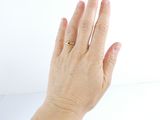 a woman ' s hand with a gold ring on it