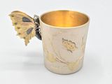 a gold cup with a butterfly on it