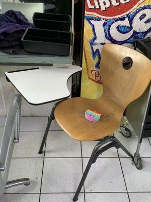 une chaise et une table dans une pièce où est accrochée une affiche au mur