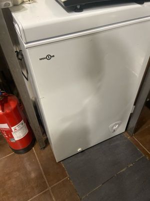 un petit réfrigérateur blanc sur lequel est posé un ordinateur portable