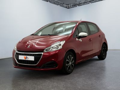 La voiture rouge est garée dans une grande pièce aux murs blancs.