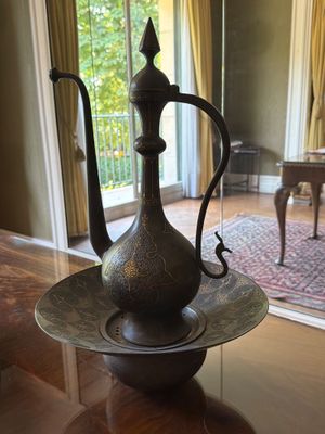 une théière en métal posée sur une table en verre
