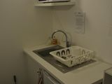une petite cuisine équipée d'un évier, d'un micro-ondes et d'un lave-vaisselle