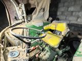 a green and yellow engine in a dirty truck