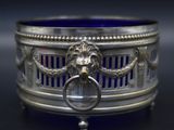 an antique silver and blue glass bowl with a lion ' s head on it