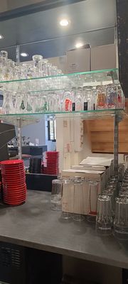 un bar avec beaucoup de verres sur les étagères